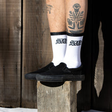 Load image into Gallery viewer, White socks with black top and toe on a wooden block sad sock
